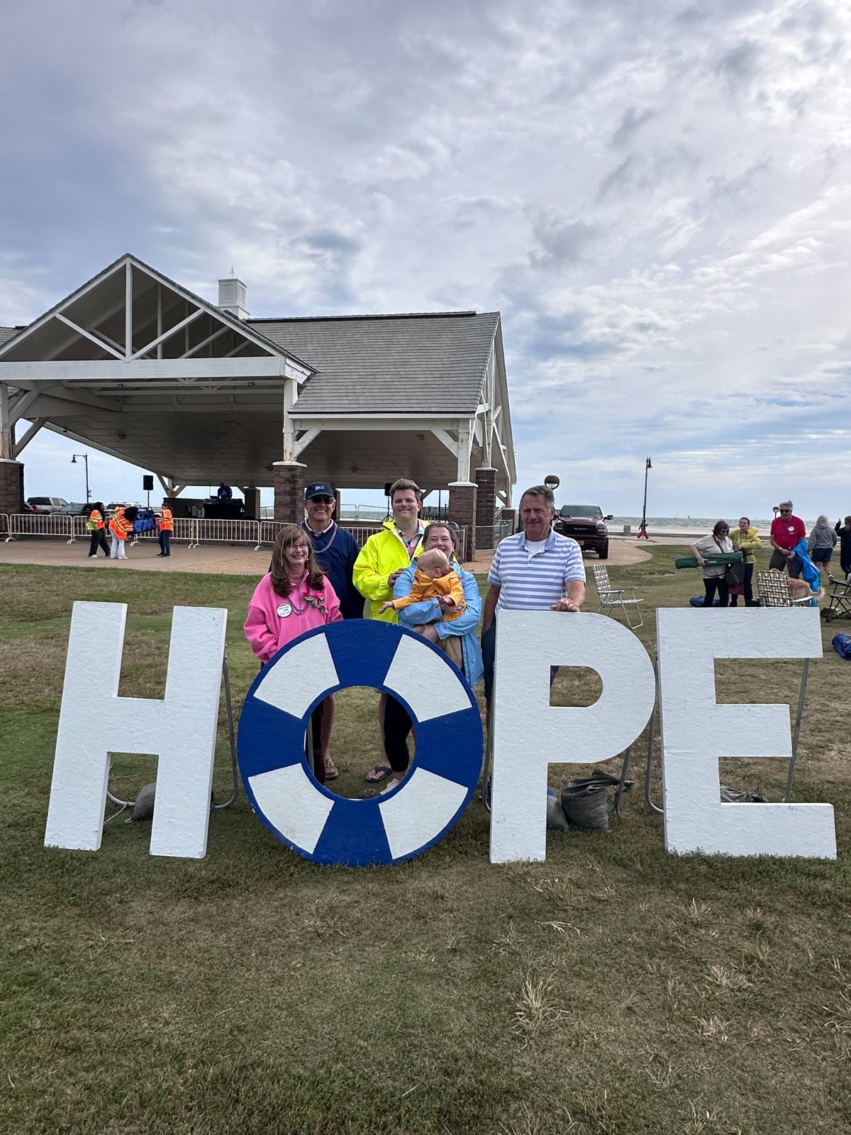 Artisan Counseling family and supporters standing behind the HOPE sign at the Virginia Peninsula Out of the Darkness Walk at Buckroe Beach